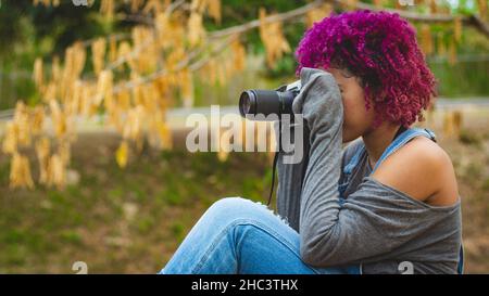 Une jeune fille qui se consacre à la photographie se prépare de la maison à aller prendre des photos de Banque D'Images