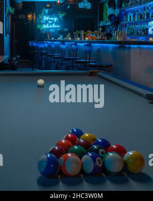 Plan vertical d'une table de billard avec boules organisées dans un bar éclairé Banque D'Images