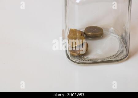 Composition avec pièces de monnaie économisant dans un pot en verre. Concept d'investissement et de maintien de l'argent, isolé. Banque D'Images