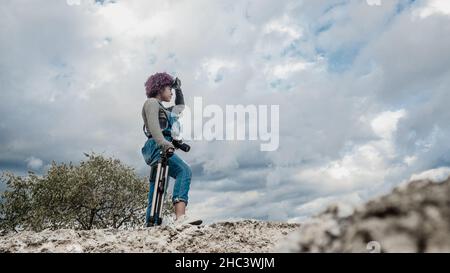 Une jeune fille qui se consacre à la photographie se prépare de la maison à aller prendre des photos de Banque D'Images