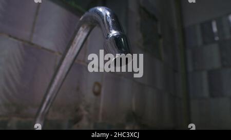 Image d'un écoulement d'eau du robinet dans une mauvaise salle de bains Banque D'Images