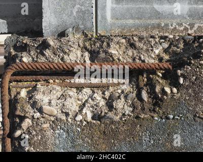 béton armé endommagé avec barres de résistance en acier rouillé exposées arrière-plan industriel Banque D'Images