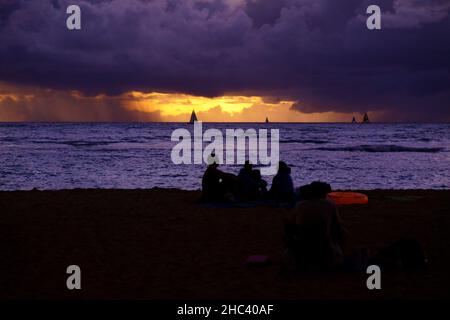 Silhouette d'un groupe d'amis profitant d'un coucher de soleil sur un bord de mer Banque D'Images