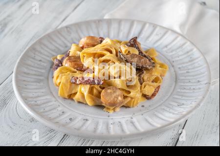 Champignons à l'ail crémeux et pâtes tagliatelli au bacon Banque D'Images