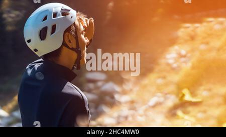 Le voyageur dans un casque regarde le sentier au coucher du soleil. Banque D'Images