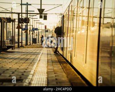 22 décembre 2021, Hessen, Wiesbaden: Un passager de train monte son vélo dans un S-Bahn.Depuis les premières heures de la matinée, les trains de banlieue, les trains régionaux de Bahn, Vias et HLB ont de nouveau été programmés par la ligne principale pour la capitale de l'État.Depuis la mi-juin 2021, la station était presque fermée.La chaussée du pont de Salzbachtal délabré avait coulé, des parties en béton tombaient sur la ligne de chemin de fer ci-dessous et les services ferroviaires devaient être suspendus sur cette section.Photo: Andreas Arnold/dpa Banque D'Images