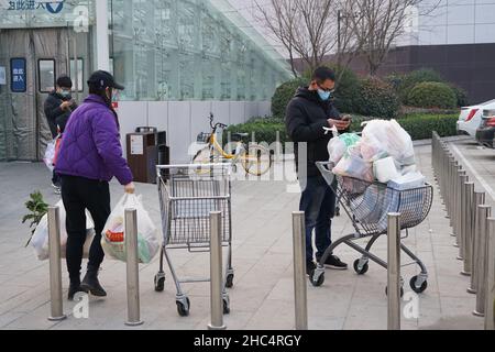 XI'AN, CHINE - 24 DÉCEMBRE 2021 - les gens emballez les nécessités quotidiennes dans un supermarché à Xi 'an, province de Shaanxi, Chine, 24 décembre 2021. Banque D'Images