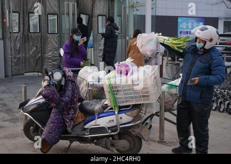 XI'AN, CHINE - 24 DÉCEMBRE 2021 - les gens emballez les nécessités quotidiennes dans un supermarché à Xi 'an, province de Shaanxi, Chine, 24 décembre 2021. Banque D'Images