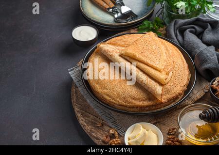 Une pile de crêpes russes fines frites sur fond sombre. Banque D'Images