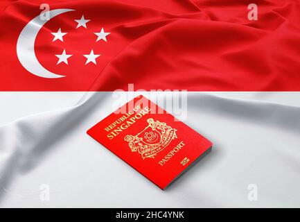 Passeport de Singapour sur le dessus d'un drapeau de Singapour en satin Banque D'Images