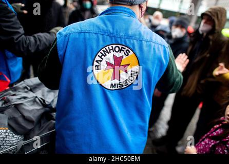 Brême, Allemagne.24th décembre 2021.Les employés de la mission de la gare de Brême distribuent des sacs d'épicerie et des cadeaux aux personnes dans le besoin devant la gare principale.Plusieurs chariots pleins de sacs ont été distribués à environ 100 personnes la veille de Noël.Credit: Hauke-Christian Dittrich/dpa/Alay Live News Banque D'Images