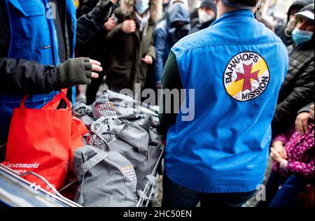 Brême, Allemagne.24th décembre 2021.Les employés de la mission de la gare de Brême distribuent des sacs d'épicerie et des cadeaux aux personnes dans le besoin devant la gare principale.Plusieurs chariots pleins de sacs ont été distribués à environ 100 personnes la veille de Noël.Credit: Hauke-Christian Dittrich/dpa/Alay Live News Banque D'Images