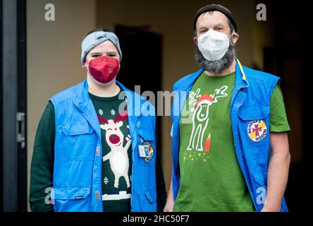 Brême, Allemagne.24th décembre 2021.Marieke Grupe et Jens Jürgenbering, tous deux employés de la mission de la gare de Brême, se tiennent devant la gare centrale après avoir distribué de nombreux sacs d'épicerie et cadeaux aux personnes dans le besoin.Plusieurs chariots pleins de sacs ont été distribués par la mission de la gare de Brême la veille de Noël.Credit: Hauke-Christian Dittrich/dpa/Alay Live News Banque D'Images