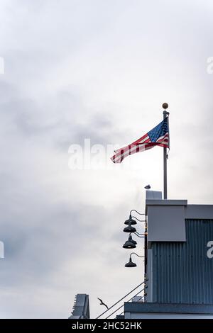 Plan vertical d'un drapeau américain soufflant sur le toit d'un bâtiment Banque D'Images