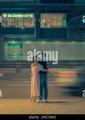 Photo verticale d'un couple pendant une nuit d'été dans la ville de Séoul, en Corée du Sud Banque D'Images