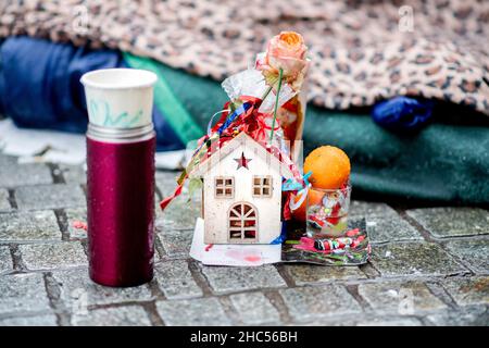 Brême, Allemagne.24th décembre 2021.Une petite maison de Noël se trouve devant les effets personnels d'un sans-abri sur la piste de la gare principale.À plusieurs endroits à Brême, des repas chauds ou des sacs avec de la nourriture et des cadeaux sont distribués aux sans-abri et aux personnes dans le besoin à la veille de Noël.Credit: Hauke-Christian Dittrich/dpa/Alay Live News Banque D'Images