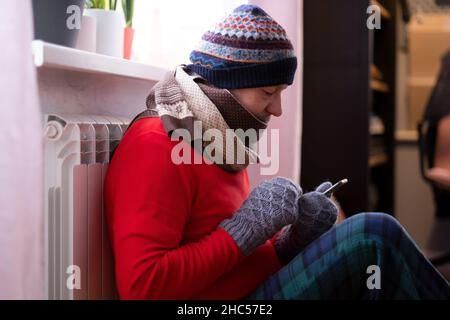 Homme se sentant froid à la maison avec des problèmes de chauffage à la maison Banque D'Images