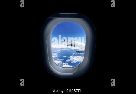 Vue sur l'aile de l'avion et les nuages à travers le hublot. Banque D'Images