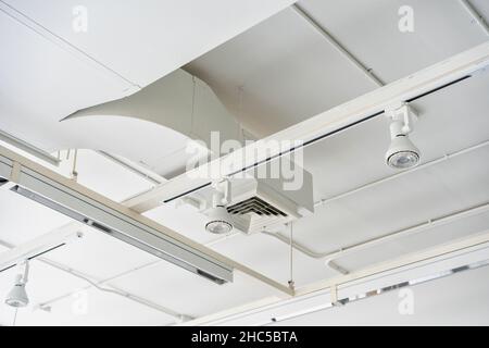 Unités de climatisation de type cassette montées au plafond avec d'autres parties du système de ventilation (tubes, câbles et évents) situées à l'intérieur du hall commercial avec Banque D'Images