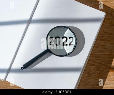 2022 ans à travers la loupe sur le livre avec vide nouvelle page.Concept de départ à partir de zéro. Banque D'Images