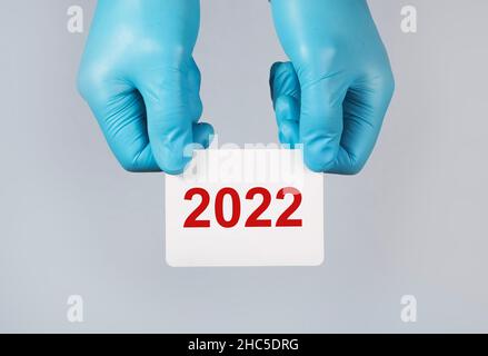 nouvelle année 2022, le concept médical entre les mains sur l'arrière-plan. Banque D'Images