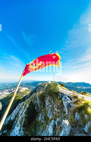 Flopping dans le vent au parc national de Lovcen, se tenant fièrement dans les couleurs rouge et or à côté du Mausolée de Njegos, une destination touristique importante et res Banque D'Images