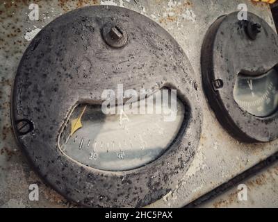 Ancienne échelle d'ampéromètres vintage, sur une interface industrielle abandonnée rouillée. Banque D'Images