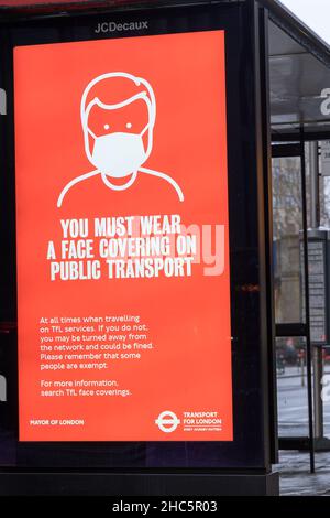 Transport pour LONDRES TFL publicité vous devez vous couvrir un visage sur les transports publics" sur JCDecaus écran LED sur le côté de la route Angleterre Royaume-Uni Banque D'Images
