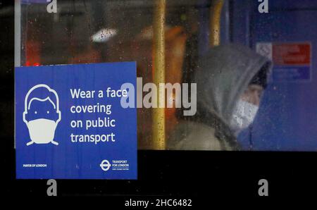 Londres, Grande-Bretagne.24th décembre 2021.Un homme portant un masque facial est vu dans un bus la veille de Noël à Londres, en Grande-Bretagne, le 24 décembre 2021.La Grande-Bretagne a signalé 122 186 autres cas de coronavirus au cours de la dernière période de 24 heures, dépassant 120 000 cas quotidiens pour la première fois depuis le début de la pandémie, selon les chiffres officiels publiés vendredi.Crédit : Li Ying/Xinhua/Alay Live News Banque D'Images