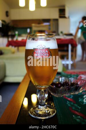 Gros plan de la bière belge Stella Artois dans un verre à l'intérieur d'un immeuble d'appartements avec un fond délavé Banque D'Images