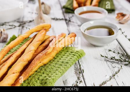 Gressins croustillants au graissini.Pain de blé italien traditionnel à l'ail, au fromage et aux graines de sésame.Cuisine méditerranéenne mortivie sur un fond rustique Banque D'Images