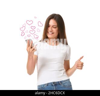 Belle jeune femme avec téléphone envoyant un message d'amour sur fond blanc Banque D'Images