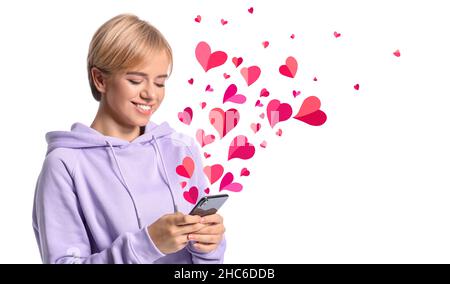 Belle jeune femme avec téléphone envoyant un message d'amour sur fond blanc Banque D'Images