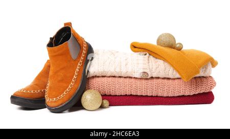 Pile de chandails tricotés, de chaussures, de chapeaux et de boules de Noël sur fond blanc Banque D'Images