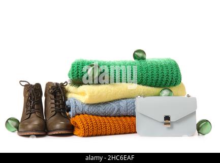 Pile de chandails chauds, de chaussures, de sacs et de boules de Noël sur fond blanc Banque D'Images