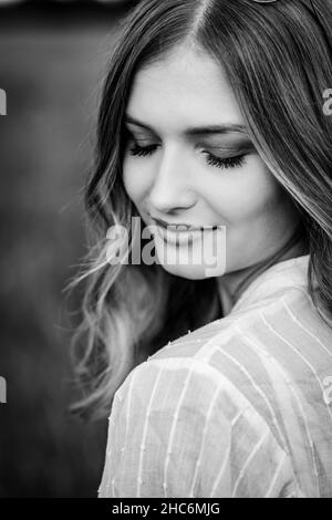 Photo verticale en niveaux de gris d'une jeune fille avec les yeux fermés. Banque D'Images