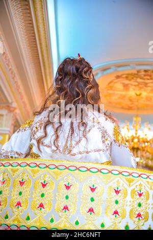 Belle mariée qui met la couronne de princesse et habillée dans le caftan marocain, sur l'Amaria , célébrant son mariage Banque D'Images