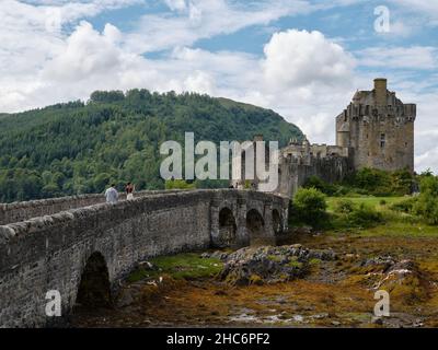 Les touristes d'été traversant le château d'Eilean Donan à Loch Duich, Kyle de Lochalsh, West Highlands Scotland UK Banque D'Images