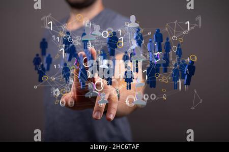 Main de l'homme tenant une illustration d'un groupe de personnes - concept de réseau Banque D'Images