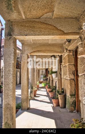 Soportal y macetas bajo tradicionales casas de piedra en el pueblo médiéval de Combarro, España Banque D'Images