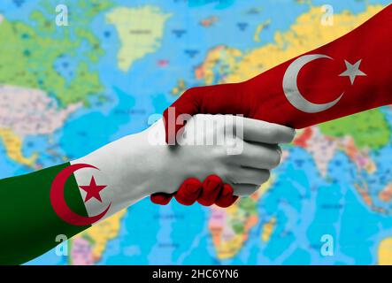 Poignée de main entre la Turquie et l'Algérie drapeaux peints à mains.avec fond de la carte du monde Banque D'Images