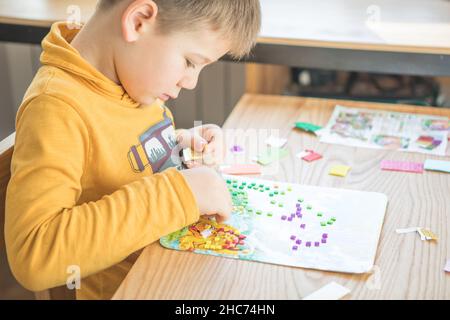 Petit garçon en étant créatif faire maison faites-le vous-même mosaïque de dinosaure.Soutenir la créativité, l'apprentissage par la pratique, l'apprentissage par l'expérience.Aide Banque D'Images