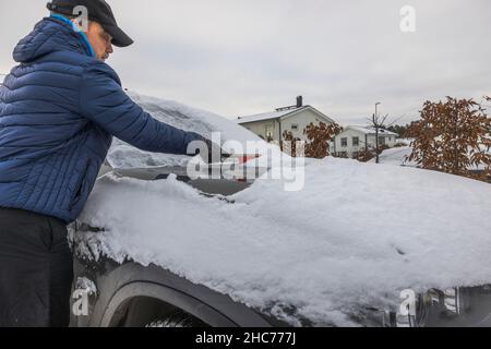 Vue rapprochée de l'homme qui nettoie le pare-brise de la neige.Contexte du concept de véhicule.Suède. Banque D'Images