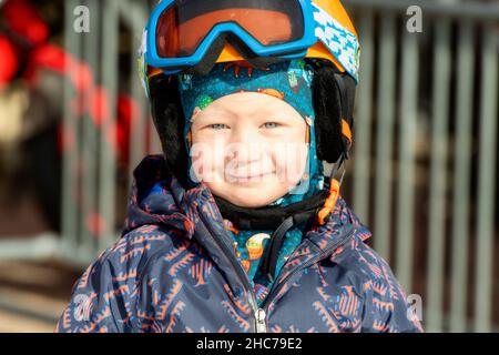 Bébé Garçon habillé chaudement et en bon équipement de sécurité prêt à Ski Banque D'Images