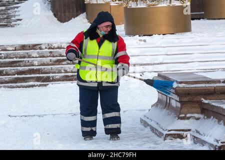 Moscou, Russie.25th décembre 2021 un employé des services communautaires enlève de la neige après une chute de neige sur la place Manège, dans le centre-ville de Moscou, en Russie Banque D'Images