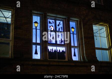 Le calendrier Saltaire vivant de l'Avent est une caractéristique du village depuis 2006.En 2020, un nombre record de 55 fenêtres ont été ouvertes à la veille de Noël, avec 16 maisons et bâtiments communautaires illuminés du 1st décembre, puis au moins une nouvelle fenêtre étant «ouverte» chaque soir jusqu'au 24th décembre.Saltaire Village est près de Bradford dans le West Yorkshire, en Angleterre.Il porte le nom de Sir Titus Salt qui a construit une usine de textile, connue sous le nom de Salts Mill et ce village sur la rivière aire.Conçu par des architectes, Lockwood et Mawson, Saltaire possède une belle architecture italienne. Banque D'Images