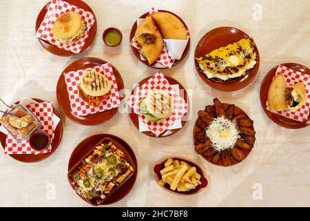 Table avec cuisine latino-américaine, Arepas vénézuélien, empanadas, platano avec fromage. Banque D'Images