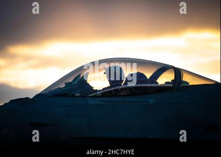 Un pilote de faucon de combat F-16C de la Force aérienne des États-Unis affecté à l'escadron de combat expéditionnaire 55th attend sur la ligne de vol pendant une opération de ravitaillement en fosse chaude dans le cadre d'un exercice d'emploi de combat Agile à un endroit non divulgué, le 21 décembre 2021.ACE est un concept opérationnel qui exploite des réseaux de bases aériennes bien établies et austères, des avions multi-capables, des équipements de pré-positionnement et des moyens de transport aérien pour déployer, disperser et manœuvrer rapidement des capacités de combat dans un théâtre.Associé aux activités de ravitaillement, d'armement et de maintenance limitée des avions, ACE élargit le nombre de bases de W Banque D'Images