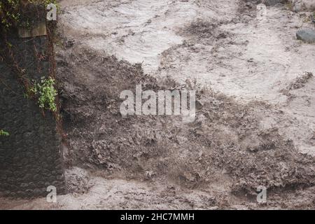 une rivière qui est inondée au bord d'une forêt encore belle et protégée coule dans le village local Banque D'Images