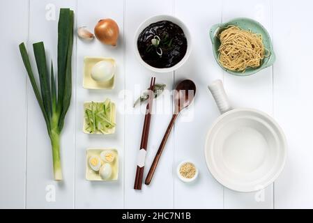 Nourriture Knolling asiatique Noodle, Flat Lay concept Ingrédients de Jajangmyeon ou Jjajangmyeon, nouilles coréennes avec sauce aux haricots noirs.Sur fond de bois blanc Banque D'Images